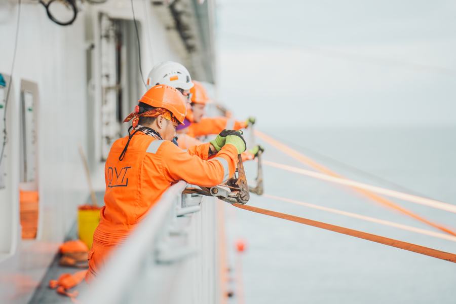 Offshore crew member in safety gear working on deck